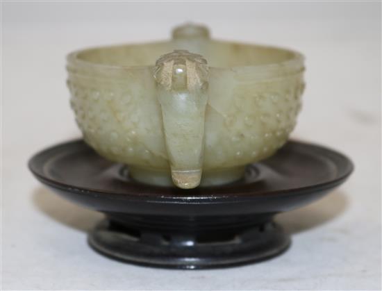 A Chinese celadon jade two handled cup, 17th century, width 12.5cm, rosewood stand